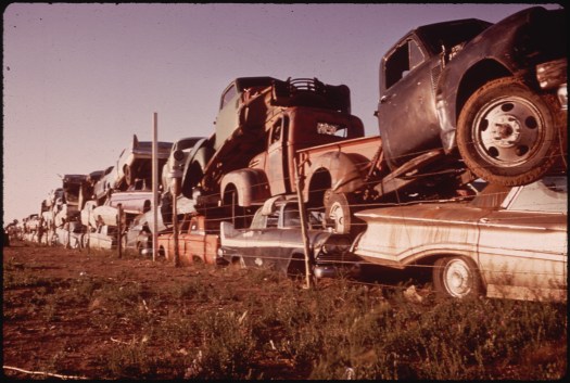 Junked Automobiles Are Piled Three Deep Along Fence